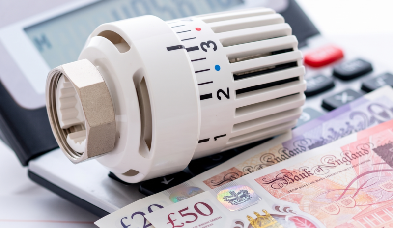 calculator on an energy data sheet with money and a TRV on top